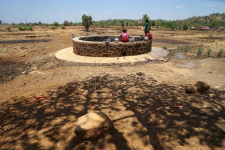 Téléchargez les photos : Femmes recueillant l'eau du puits du village de Dhakne, Shahapur Thane Maharashtra, Inde, Asie - en image libre de droit