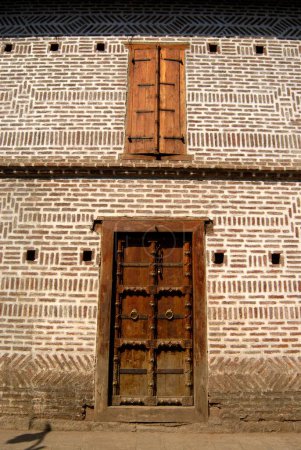Puerta tallada en madera rica fijada en ladrillo en la entrada del segundo palacio de Vishrambaug Wada de Peshve el rey de Maratha; Pune; Maharashtra; India