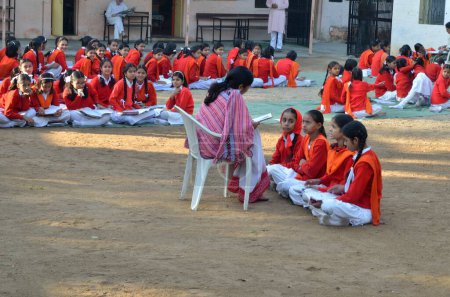 Téléchargez les photos : Enseignant Enseignement aux filles assises sur un terrain découvert Sirohi Rajasthan Inde Asie - en image libre de droit