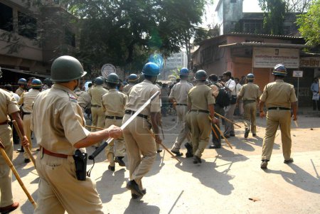 Téléchargez les photos : Des policiers patrouillent lorsque des émeutiers cassent des vitres de véhicules à Bhandup après que la communauté dalit a eu recours à des manifestations violentes, Bombay maintenant Mumbai, Maharashtra, Inde - en image libre de droit