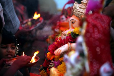 Photo for Devotees performing puja of Lord Ganesha ganpati Hindu deity before immersion,  Bombay Mumbai, Maharashtra, India - Royalty Free Image