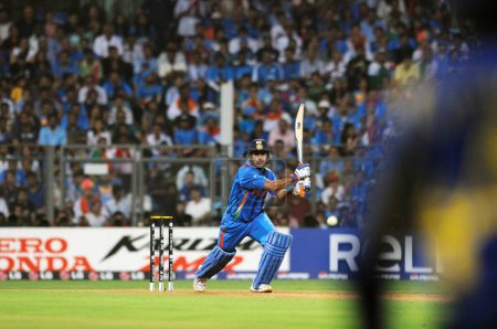 Téléchargez les photos : Capitaine indien, batteur M S Dhoni joue sa chance lors de la finale de la Coupe du monde ICC 2011 entre l'Inde et le Sri Lanka au stade Wankhede le 2 avril 2011 à Mumbai en Inde - en image libre de droit