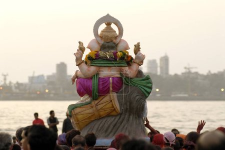 Back pose of Idol of lord Ganesh ganpati during immersion at Mahim beach Mumbai Bombay ; Maharashtra ; India