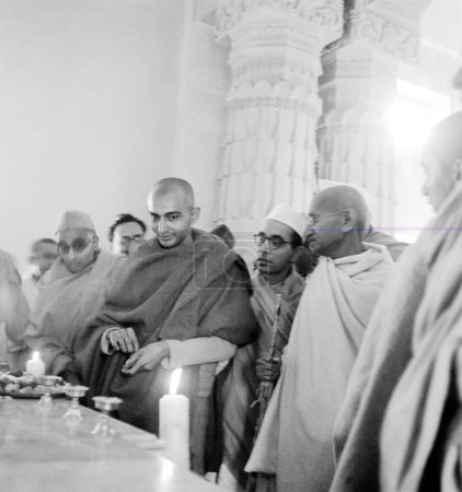 Téléchargez les photos : Mahatma Gandhi, Pyarelal Nayar, un moine bouddhiste et d'autres visitant le temple Sarnath, Varanasi, 1941, Inde - en image libre de droit