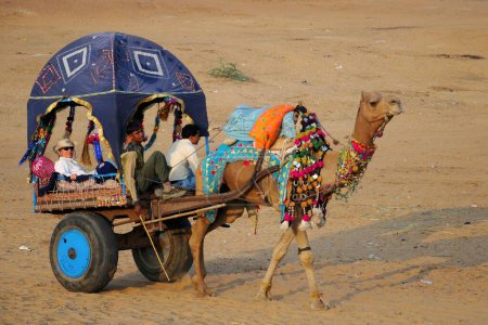 Foto de Personas que viajan en carro de camello para la feria de Pushkar; Rajastán; India - Imagen libre de derechos