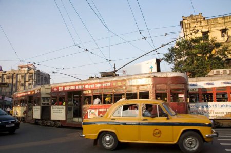 Téléchargez les photos : Tram dans l'ancienne façon de service de navette et taxi de couleur jaune sur la route ; Calcutta maintenant Kolkata ; Bengale occidental ; Inde - en image libre de droit
