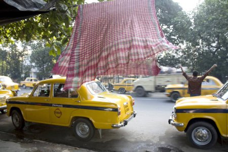 Téléchargez les photos : Kiosque de taxis jaunes et serviette volante, Calcutta maintenant Kolkata, Bengale occidental, Inde - en image libre de droit