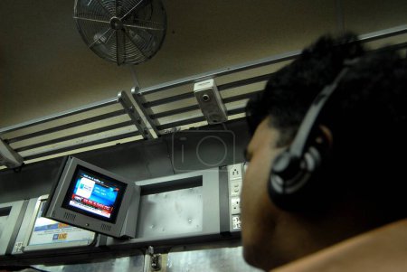 Foto de Pasajeros viendo la televisión introducida por Indian Railways de forma experimental en uno de los bogie con aire acondicionado en la estación central de Mumbai en Bombay Mumbai; Maharashtra; India - Imagen libre de derechos