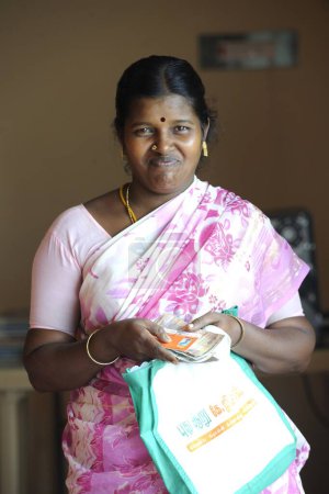 Foto de Señora rural con efectivo y tarjeta de identidad del banco por ngo kshtriya gramin servicios financieros por la fundación IFMR, Thanjavur, Tamil Nadu, India - Imagen libre de derechos