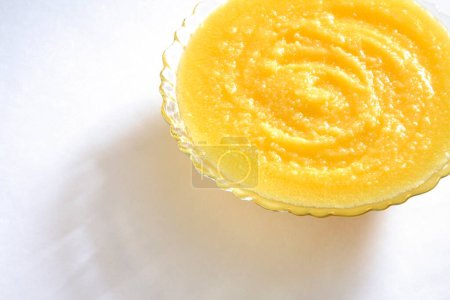 Foto de Ghee amarillo dorado casero granular puro en tazón de cristal sobre fondo blanco - Imagen libre de derechos