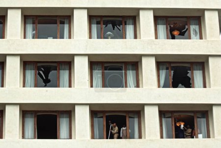 Foto de Trabajadores limpian ventanas del hotel Trident tras ataque terrorista de muyahidines decanos en Bombay Mumbai - Imagen libre de derechos