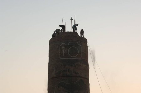 Téléchargez les photos : Ouvriers brisant Elphinstone Mills Cheminée, Mumbai, Maharashtra, Inde, Asie - en image libre de droit