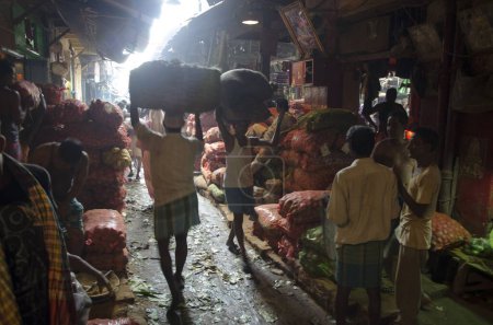 Foto de Hombre llevando saco de verduras en el mercado Kolkata Bengala Occidental India Asia - Imagen libre de derechos