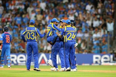 Téléchargez les photos : Le joueur sri-lankais 2L Mahela Jaywerdena saute sur ses coéquipiers pour célébrer le guichet du batteur indien Virat Kohli L lors de la finale de la Coupe du monde de cricket ICC entre l'Inde et le Sri Lanka au stade Wankhede à Mumbai le 2 avril 2011 - en image libre de droit