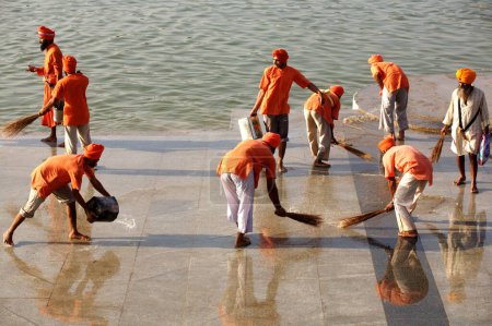 Photo for Karsevaks cleaning the Ghat for celebration of 300th year of consecration of perpetual Guru Granth Sahib, Sachkhand Saheb Gurudwara in Nanded, Maharashtra, India - Royalty Free Image