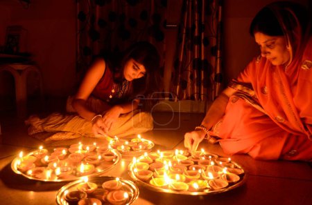 Photo for Woman and girl lighting oil lamp Diwali festival, jodhpur, rajasthan, India, Asia, NOMR - Royalty Free Image