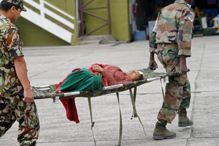 Téléchargez les photos : Personnel de l'armée transportant une personne blessée, népal, asie - en image libre de droit