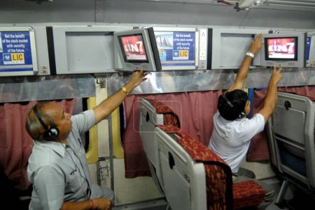 Foto de Pasajeros viendo la televisión introducida por Indian Railways de forma experimental en uno de los bogie con aire acondicionado en la estación central de Bombay Mumbai, Maharashtra, India - Imagen libre de derechos