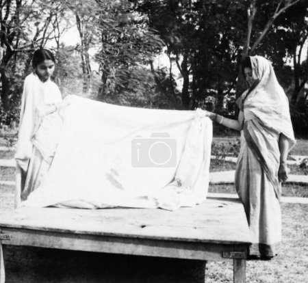 Foto de Abha Gandhi y Manu Gandhi, sosteniendo el vestido manchado de sangre que Mahatma Gandhi usó en su asesinato, 1948, Manu Gandhi, Abha Gandhi, India - Imagen libre de derechos