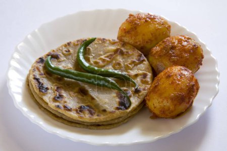 Foto de Cocina india roti chapatti pan de cada día a base de harina de trigo atta con chile verde y patata de aloo tandoori masala servida en plato, India - Imagen libre de derechos