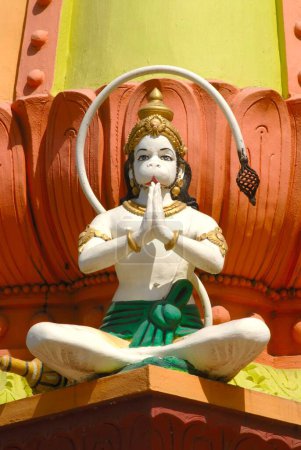 Colourfully painted stucco figure of lord Hanuman sitting with Namaskar posture ; monkey god ; Maruti in temple at foothill of Parvati ; Pune ; Maharashtra ; India