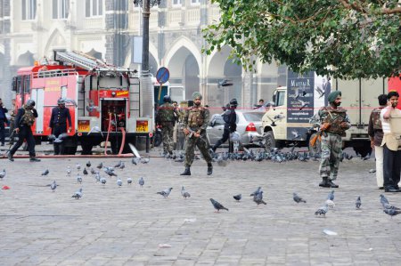 Photo for Pigeons and National Security Guard NSG commandos outside the Taj Mahal hotel ; after Terrorist attack by Deccan Mujahedeen on 26 November 2008 in Bombay Mumbai ; Maharashtra ; India - Royalty Free Image