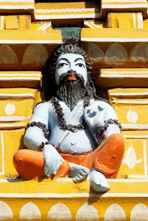 Téléchargez les photos : Sculpture colorée de sadhu exécutant du yoga sur la façade du gigantesque temple Sri Ranganathswami ; Tiruchirappalli ; Trichy ; Tamil Nadu ; Inde - en image libre de droit