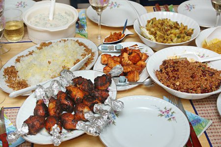 Foto de Comida, Buffet Vasos de vino, arroz Pulav, Raita (ensalada con cuajada) vegetal Kheema con frijoles rojos, tanduri Palitos de pollo, pepinillos, Pescado frito - Imagen libre de derechos