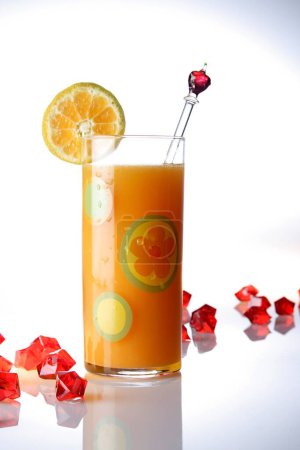 Foto de Bebidas, Zumo de naranja con una rebanada de naranja sobre fondo blanco con piezas de acrílico rojo - Imagen libre de derechos
