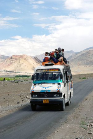 Téléchargez les photos : Touristes assis sur le sommet de la montagne minibus en arrière-plan - en image libre de droit
