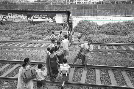 Foto de Mujeres con niños cruzando la línea ferroviaria en el barrio pobre de Islampura; Wadala; Bombay Mumbai; Maharashtra; India - Imagen libre de derechos