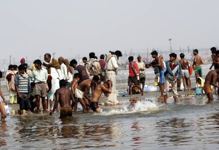 Foto de Los peregrinos se reúnen en la confluencia del Ganges, Yamuna y los míticos ríos Saraswati para darse un chapuzón durante el Ardh Kumbh Mela, uno de los festivales religiosos más grandes del mundo en Allahabad, Uttar Pradesh, India - Imagen libre de derechos