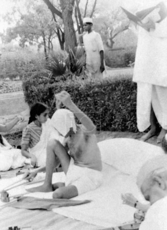Téléchargez les photos : Mahatma Gandhi spinning, New Delhi, 1939, Sushila Nayar, Mahadev Desai, Inde - en image libre de droit