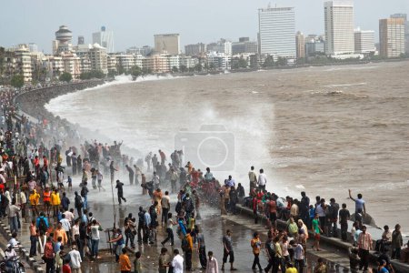 Photo for People enjoying hightide waves at marine drive Bombay ; Mumbai  ;  Maharashtra  ; India NOMR - Royalty Free Image