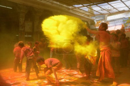 Téléchargez les photos : Prêtre verser gulaal dans Gang temple shyamji au Rajasthan Inde - en image libre de droit