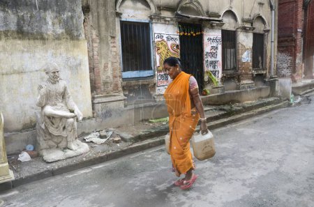 Téléchargez les photos : Femme portant de l'eau dans des canettes en plastique, Kolkata, Bengale occidental, Inde, Asie - en image libre de droit