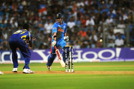 Téléchargez les photos : Le batteur indien Gautam Gambhir R atteint son point culminant lors d'une tentative de fuite du joueur sri-lankais Thisara Perera lors de la finale de la Coupe du monde de cricket 2011 entre l'Inde et le Sri Lanka au stade Wankhede à Mumbai le 2 avril 2011 - en image libre de droit