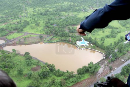 An aerial view of farming land immersed in water naval officer showing from naval helicopter Sea King over deluge scene in Raigad, Maharashtra, India 