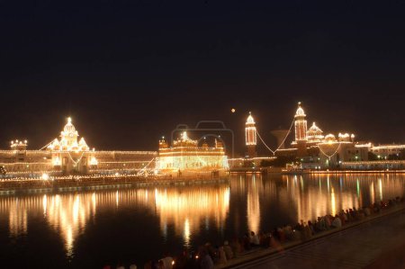 Foto de Un Templo de Oro iluminado; también conocido como Harimandir Granth Sahib; lugar sagrado de culto de los sijs en Amritsar; Punjab; India con motivo del aniversario del nacimiento del primer gurú sij Sri Guru Nanak Dev ji durante noviembre ; - Imagen libre de derechos