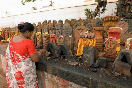 Téléchargez les photos : Femme adorant les idoles Naga dans le temple Kachabeswarar dédié au Seigneur Shiva à Kanchipuram, Tamil Nadu, Inde - en image libre de droit