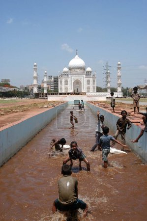 Téléchargez les photos : Une réplique de Taj Mahal ; l'une des sept merveilles du monde a été érigée lors d'une foire de l'artisanat au KJ Somaiya College of Medicine ; Sion ; sur la Eastern Express Highway à Bombay maintenant Mumbai dans le Maharashtra ; Inde Enfants profitant d'un bain dans - en image libre de droit
