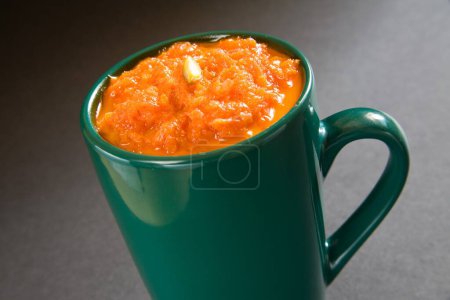 Téléchargez les photos : Nourriture indienne ; dessert sucré carottes pudding garniture de pistaches servi dans une tasse 19-février-2010 - en image libre de droit