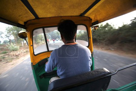 Téléchargez les photos : Auto _ rickshaw driver driving rickshaw dans les rues, Inde - en image libre de droit