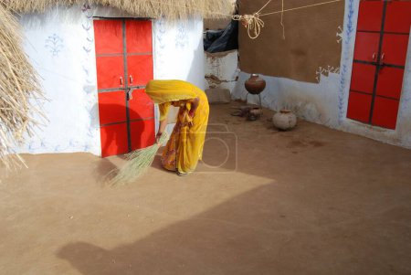 Photo for Woman cleaning hut ; Bikaner ; Rajasthan ; India - Royalty Free Image