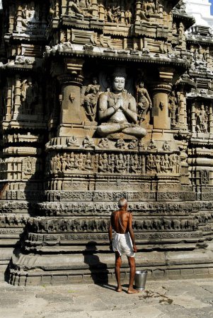 Téléchargez les photos : Vieux prêtre nettoyer Dieu Vishnu statue sur le mur du temple de Aundhanagnath l'un des douze temples Jyotirling Shiva Shivaling à Aundha près de Nanded, Maharashtra, Inde - en image libre de droit