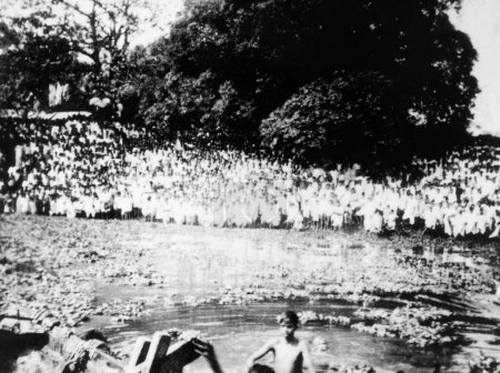 Foto de Multitud junto a un río donde se disuelven las cenizas de Mahatma Gandhi, Dhaka, febrero de 1948 - Imagen libre de derechos