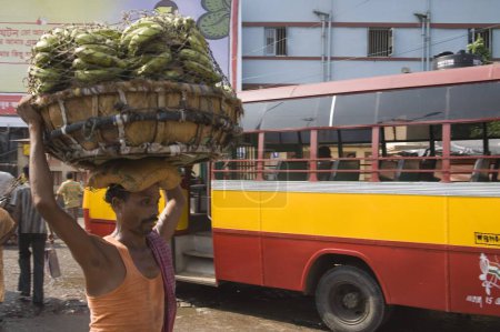 Photo for Indian man carrying load of banana on head bus stand near Howrah railway station Street scene, Calcutta now Kolkata, West Bengal, India - Royalty Free Image