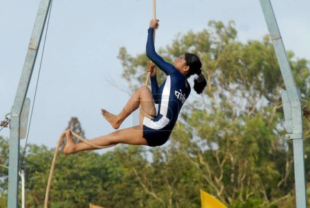 Téléchargez les photos : Rope malkhamb performance, l'ancienne forme de gymnastique indienne lors du spectacle annuel de tatouage de la police de Mumbai au parc Shivaji à Bombay maintenant Mumbai, Maharashtra, Inde - en image libre de droit