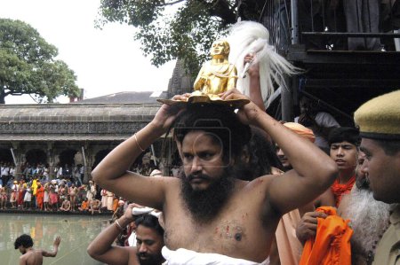 Téléchargez les photos : Les dévots portent l'idole de leur gourou sur leur tête avant de prendre un bain sacré pendant le Kumbh Mela 2003 à Trimbakeshwar, près de Nasik, Maharashtra, Inde. - en image libre de droit
