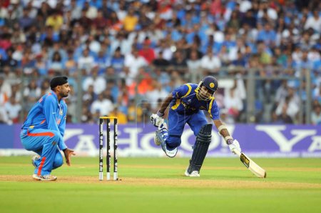 Photo for Sri Lankan batsman ,reaches the crease while Indian bowler Harbhajan Singh tries for run out during the ICC Cricket World Cup finals against Sri Lanka played at the Wankhede stadium in Mumbai on April 02 2011 - Royalty Free Image